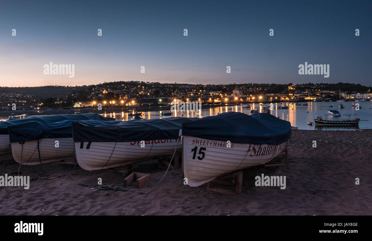 Barche sul rosso spiaggia levigata a Shaldon nel Devon di notte. Foto Stock