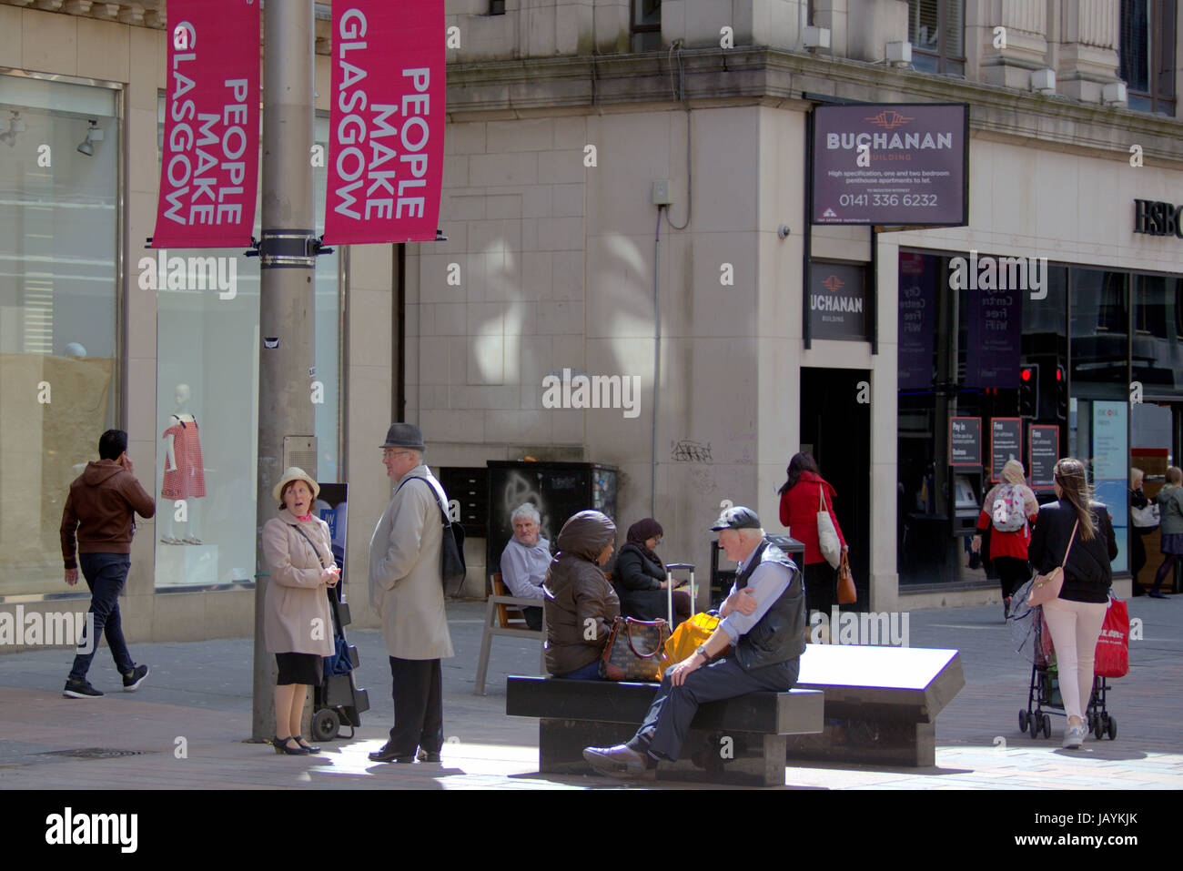 I turisti in Glasgow Scotland camminando sulla strada a parlare di shopping Foto Stock