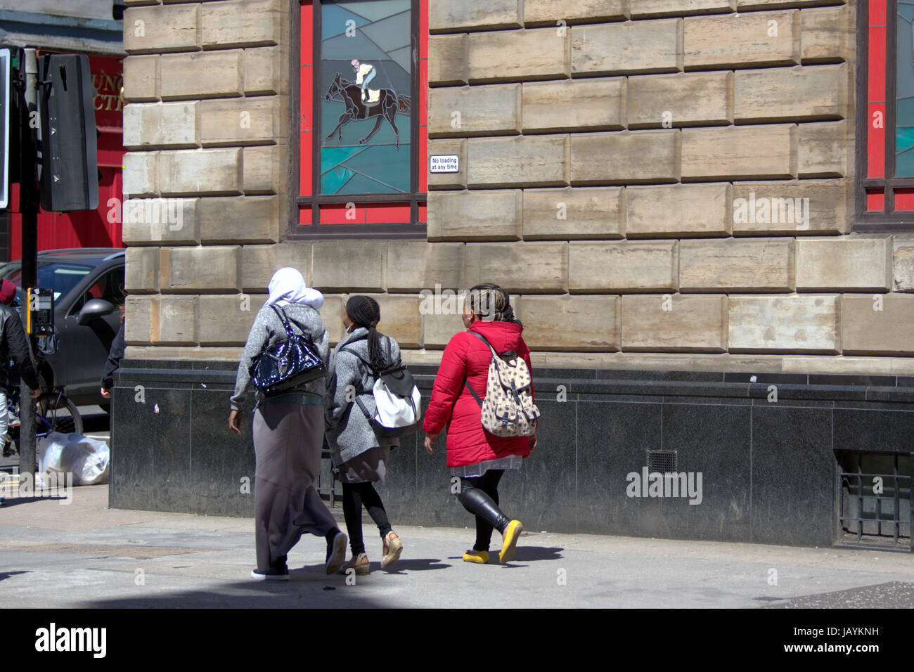 Giovane donna musulmana che indossa il hijab sciarpa camminare da solo nella città Foto Stock