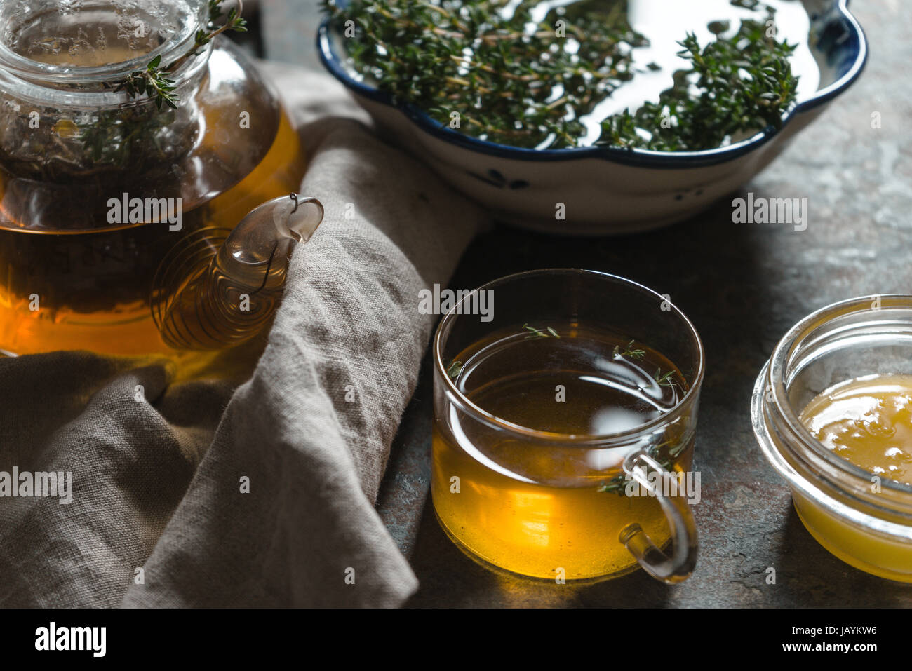 Bollitore con tè verde, il timo e il miele sul tavolo orizzontale closeup Foto Stock