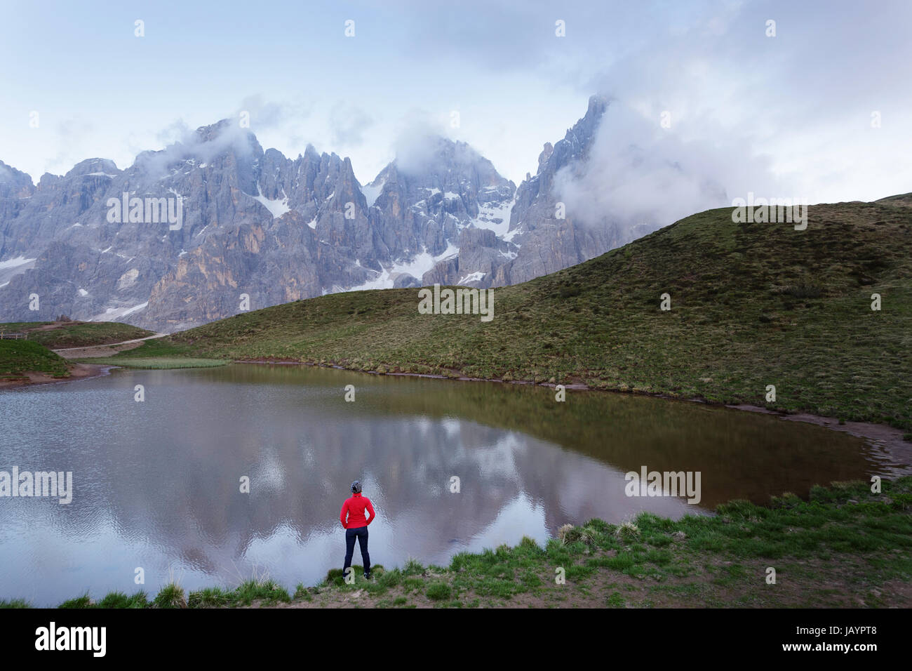 Donna in piedi dal lago a Baita Segantini, Dolomiti, Italia. Foto Stock