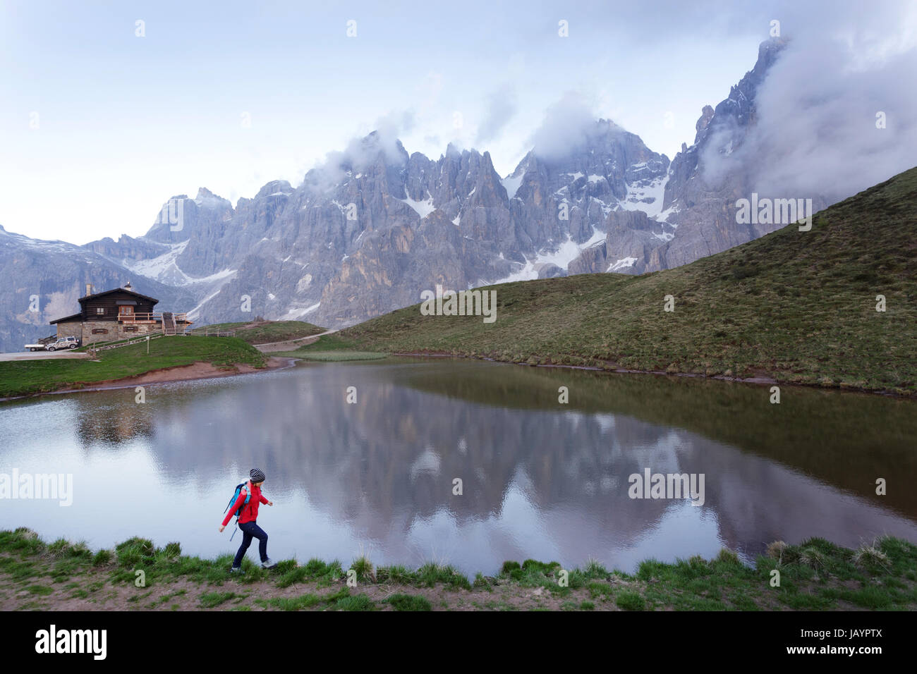 Donna in piedi dal lago a Baita Segantini, Dolomiti, Italia. Foto Stock