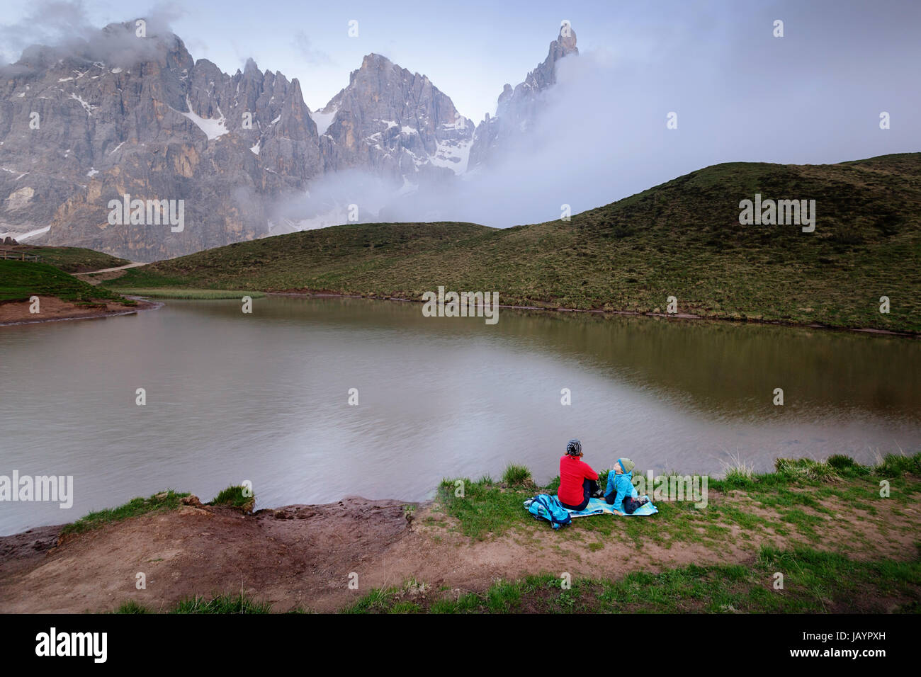 Madre e figlio avente seduta su una coperta dal lago a Baita Segantini, Dolomiti, Italia. Foto Stock
