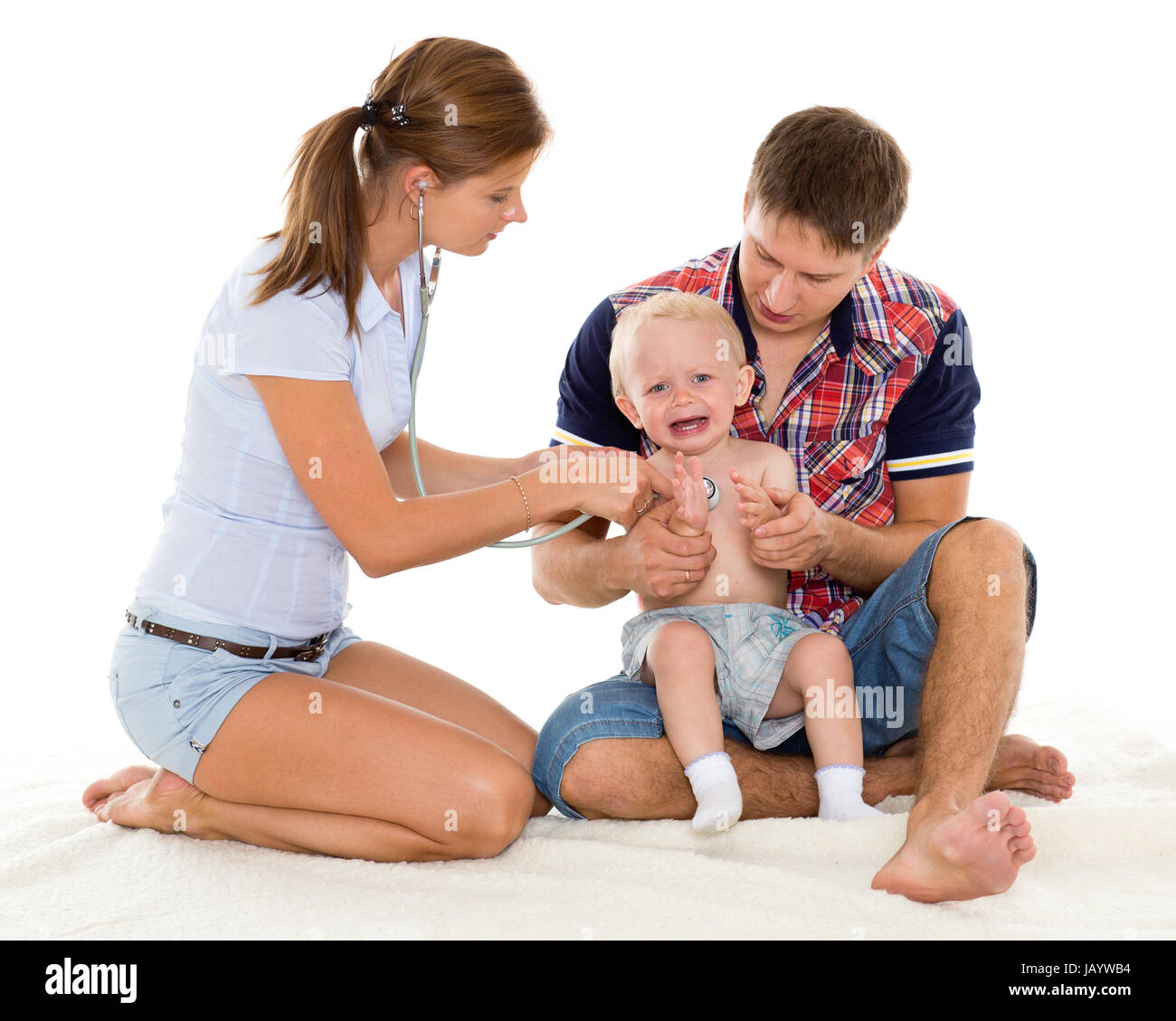 La femmina medico con uno stetoscopio e il papà con il piccolo bambino su uno sfondo bianco. Pediatria. Foto Stock