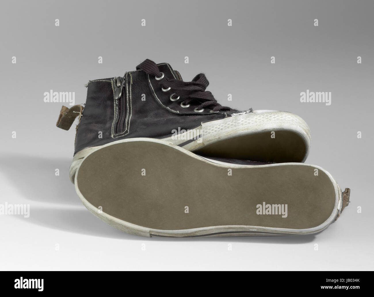 Una coppia di vecchi brown sneakers in grigio chiaro indietro Foto Stock