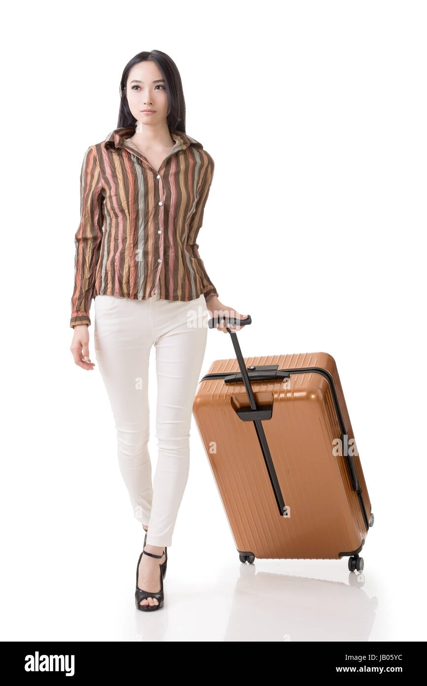 Moderna donna asiatica passeggiate a piedi e in possesso di una valigia piena lunghezza ritratto isolato su sfondo bianco. Foto Stock Moderna donna asiatica passeggiate a piedi e in possesso di una valigia piena lunghezza ritratto isolato su sfondo bianco. Foto Stock