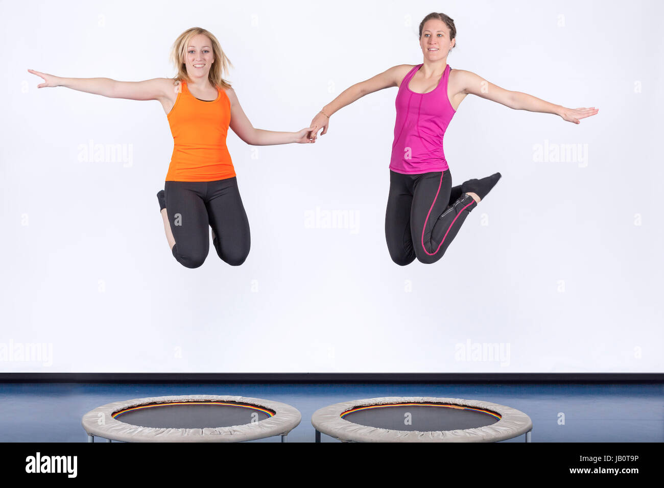 Zwei Sportlerinnen springen auf Minitrampolin Foto Stock