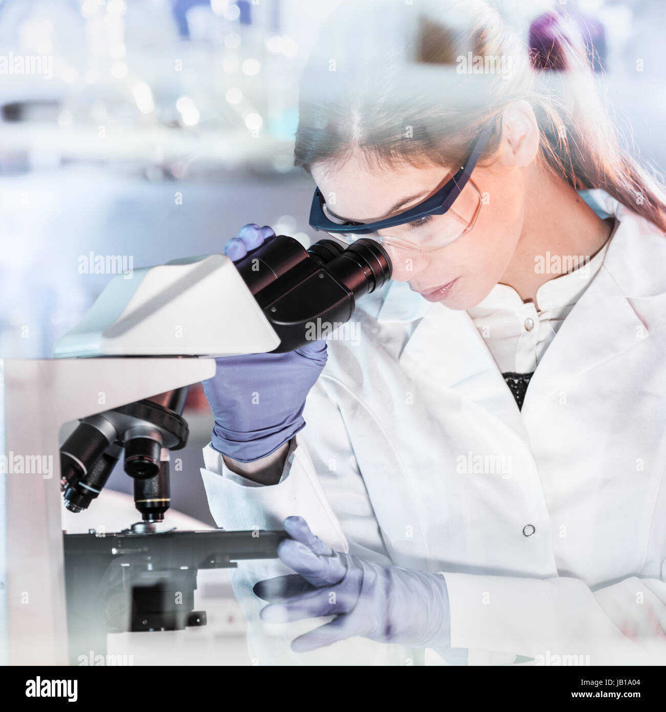 La vita gli scienziati alla ricerca in laboratorio. Femmina attraente ai giovani scienziati microscopia nel loro ambiente di lavoro. La sanità e le biotecnologie. Foto Stock