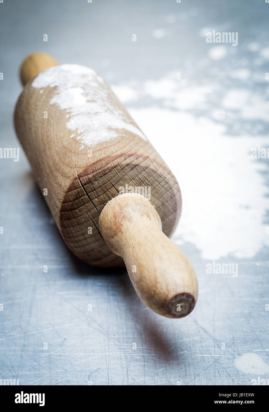 In legno antico mattarello con farina sparsi su una cucina blu superficie durante la cottura di dolci fatti in casa o la pizza Foto Stock