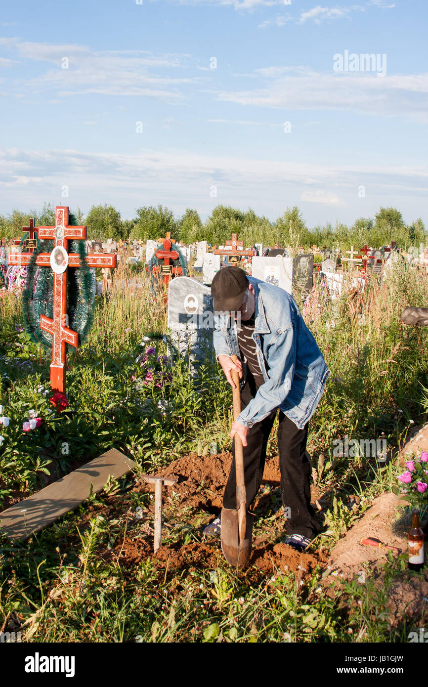 Perm, Russia - luglio 13.2016: l'uomo stabilisce una panca su una tomba su un cimitero Foto Stock