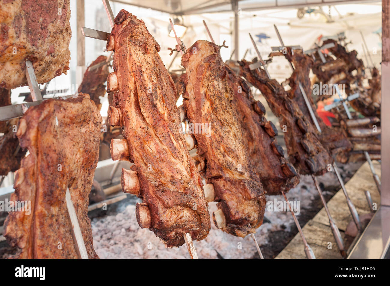 Carne arrosto di manzo cotta su griglie verticali collocati intorno al fuoco. Asado, barbecue tradizionale piatto in Argentina Foto Stock