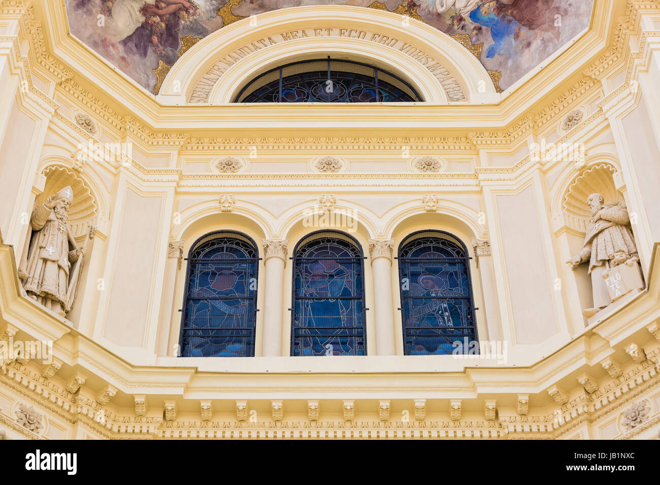 Di fronte ad una chiesa italiana, giallo crema ingresso con dipinti e statue Foto Stock