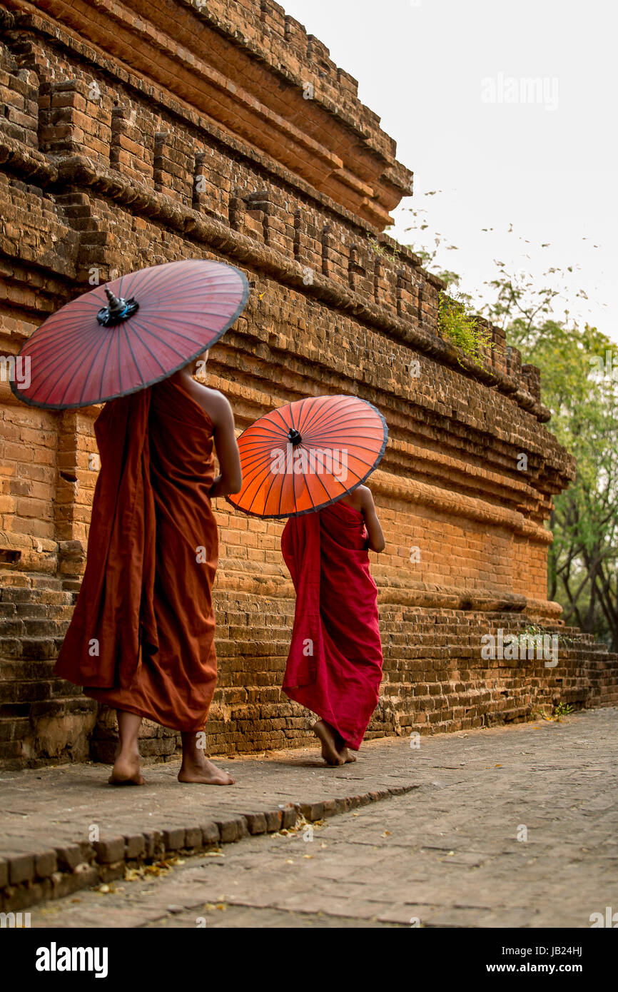 Pochi monaci in un vecchio tempio Myanmar con ombrellone Foto Stock