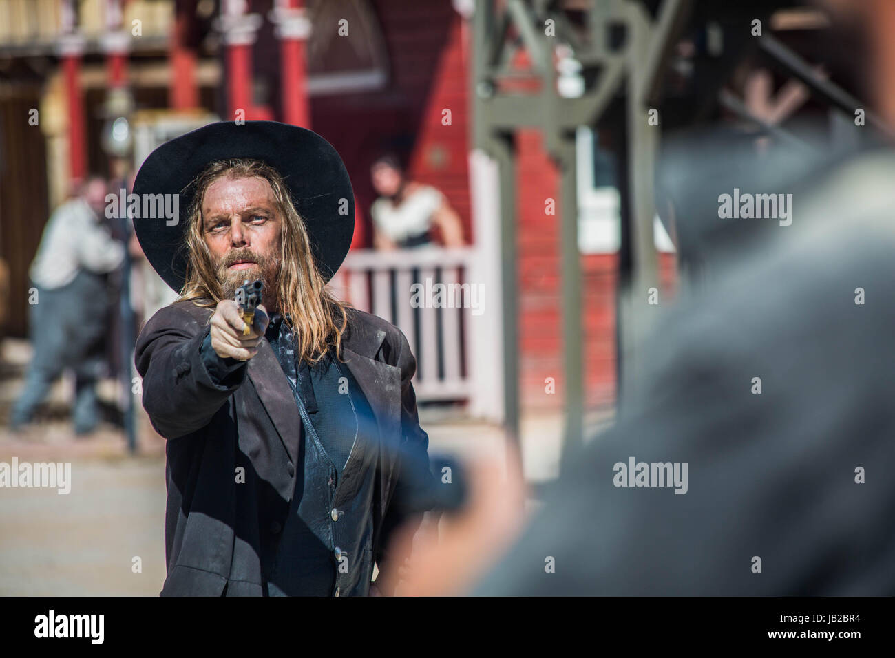 Punti Cowboy pistola a uomo nel centro della città Foto Stock