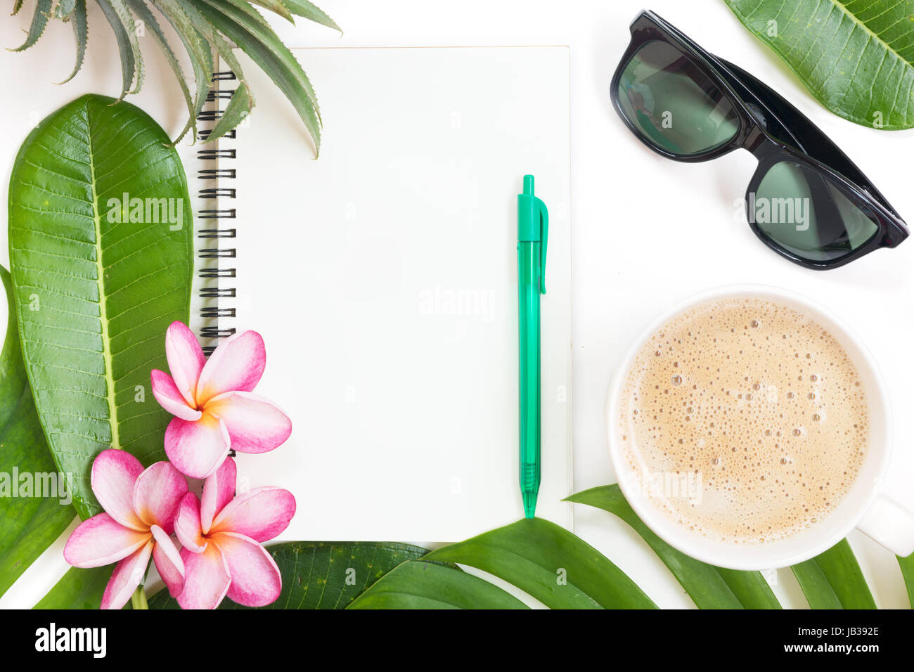 Tropic flat top laici vista botanici tropicali estate concetto con note book occhiali da sole caffè tazza di ananas a foglie di palmo e plumeria su bianco Foto Stock
