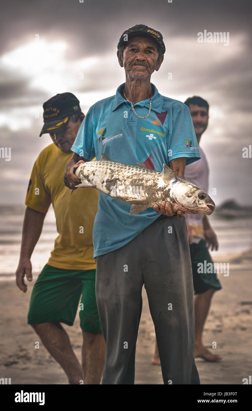 Ilha do Mel, Paraná, Brasile - 3 Giugno 2017: pescatore nativo di Ilha do Mel (Isola del Miele), tenendo un cefalo. Foto Stock