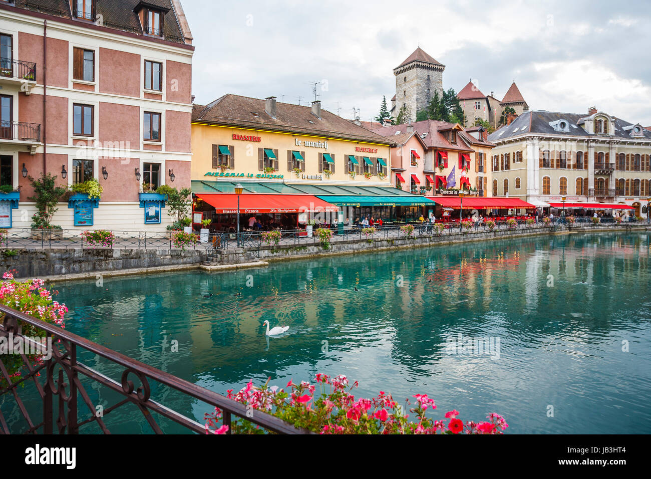 Ristoranti e caffetterie con colorati in rosso e in verde tende in edifici storici lungo la sponda del fiume Thiou nella città vecchia di Annecy, Francia Foto Stock