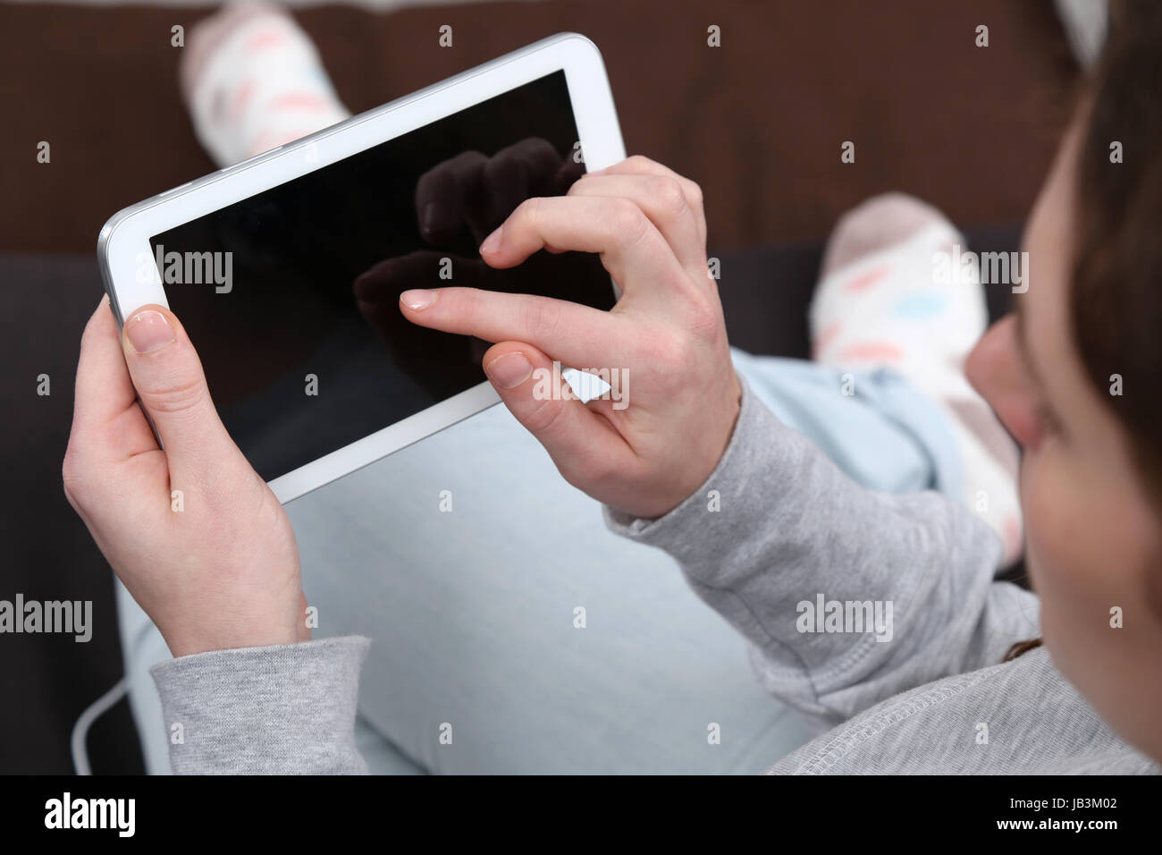 Ein junge Frau benutzt mit dem dito ihren Computer tablet Foto Stock