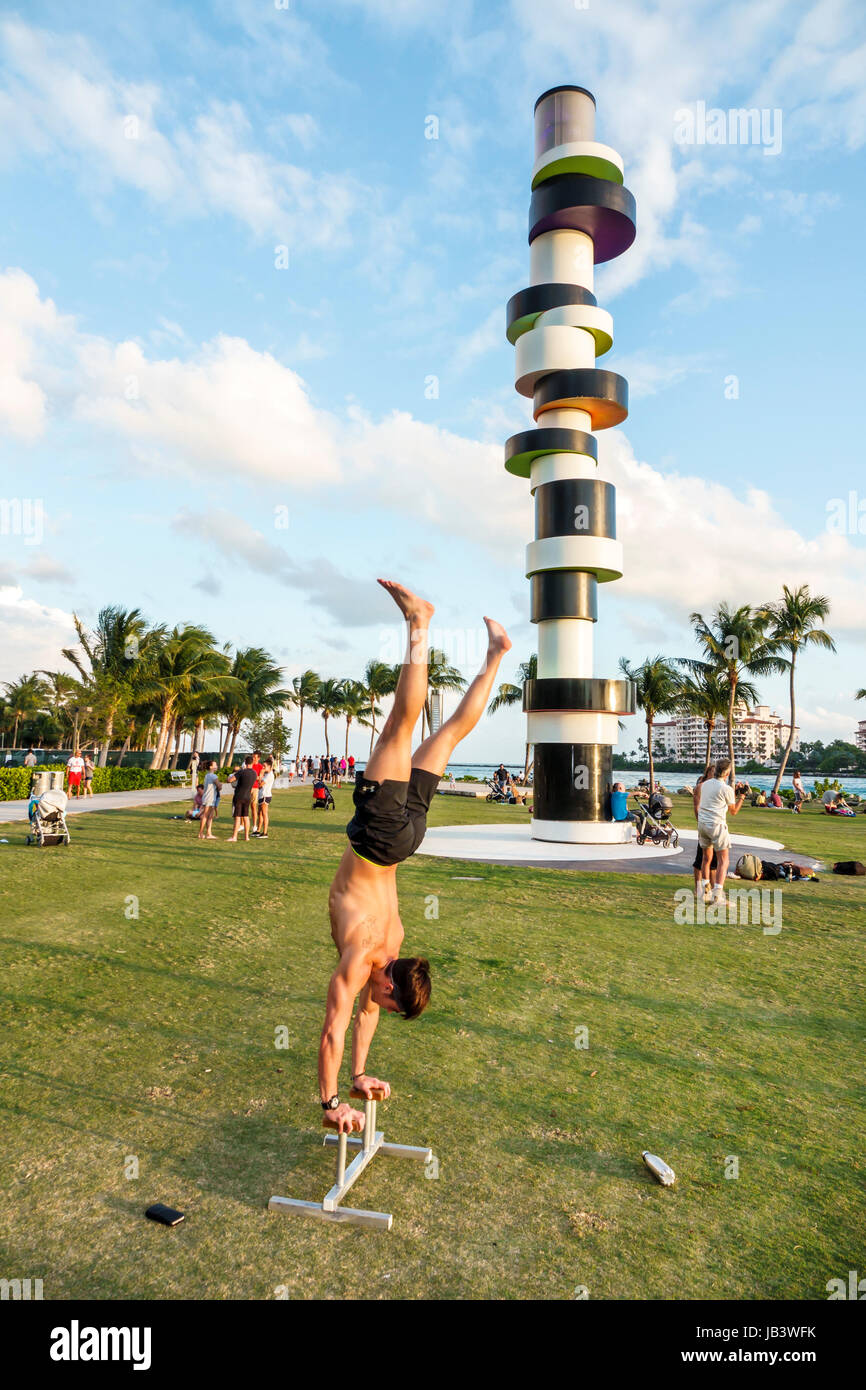 Miami Beach Florida,Government Cut,fronte mare,prato,attività ricreative all'aperto,faro ostinato,scultura,Tobias Rehberger,adulti uomo uomo maschio,acroba Foto Stock