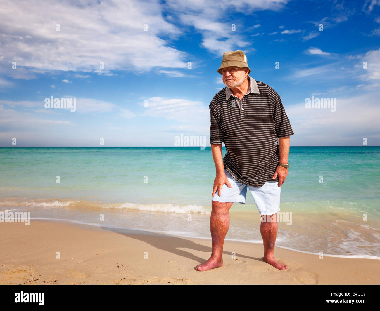 Casual Uomo senior fare esercizio sulla spiaggia Foto Stock