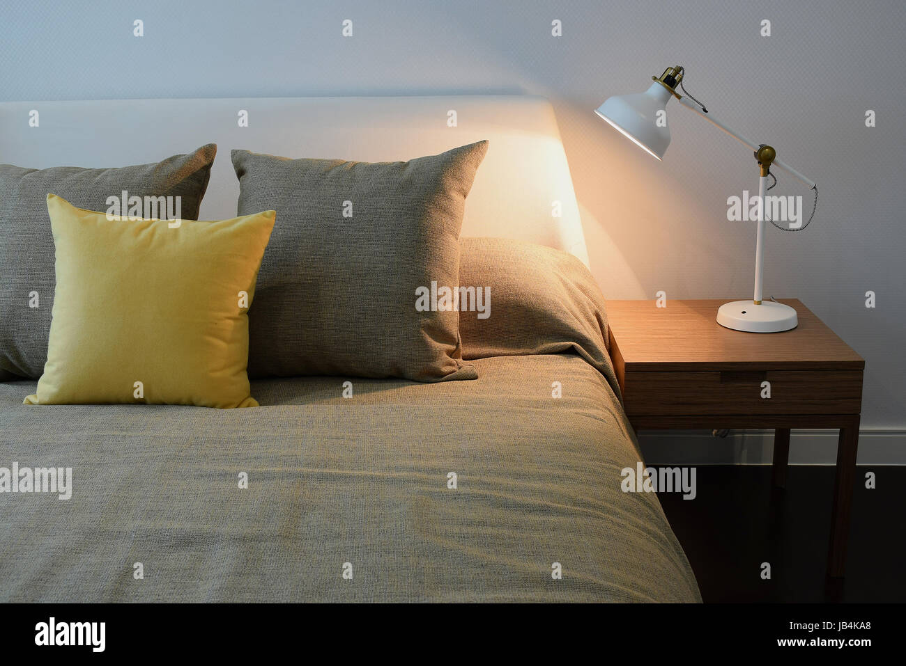 Accogliente camera da letto interno con cuscini e lampada da lettura sul comodino Foto Stock