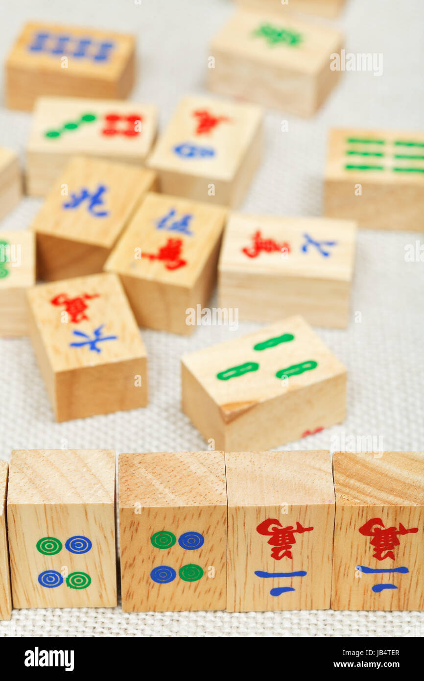Piastrelle di legno closeup in mahjong gioco durante la riproduzione su tavola tessili Foto Stock