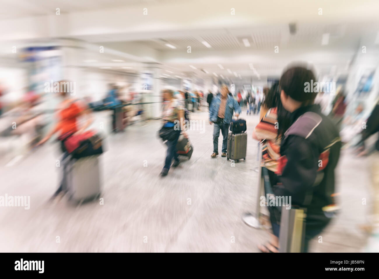 Immagine sfocata del i passeggeri in arrivo al terminal degli arrivi presso l'aeroporto internazionale Foto Stock