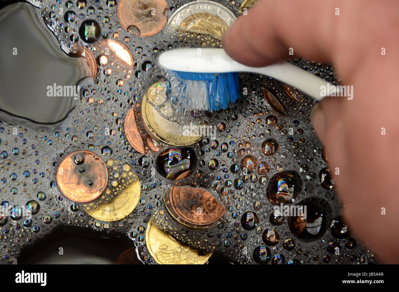 Il nero delle monete in euro di essere lavato, suggerendo il termine 'imbiancare di denaro nero' Foto Stock