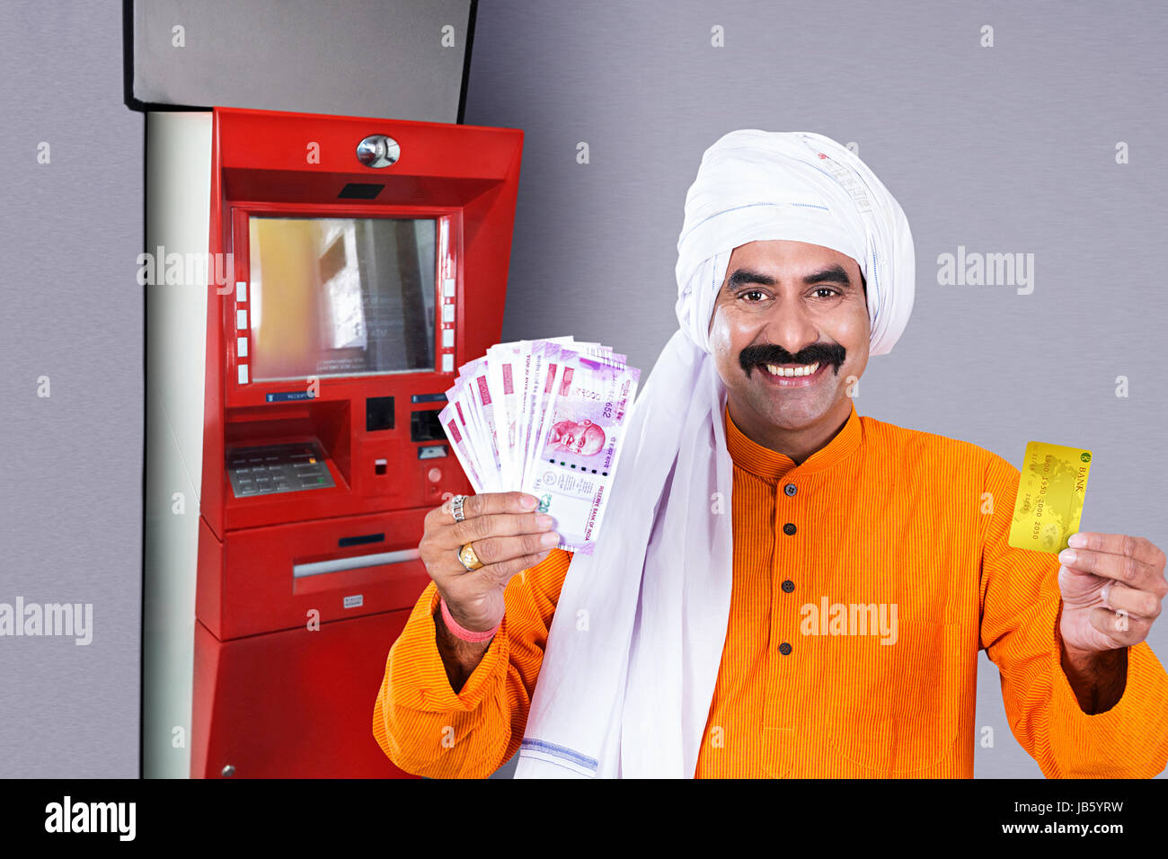 1 rurale indiano uomo agricoltore tramite Bancomat e che mostra una carta di debito con rupie note.- Bancomat ritirare il concetto di denaro Foto Stock