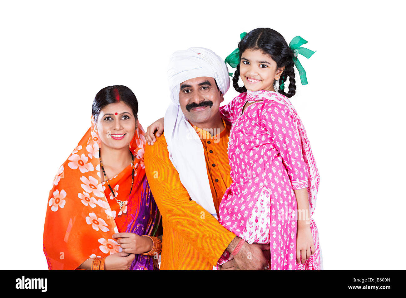 Felice rurale indiano i genitori con la loro piccola figlia in piedi insieme in Studio shot su sfondo bianco Foto Stock