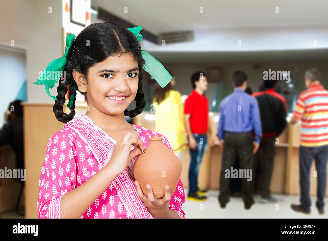 1 rurale indiano Kid ragazza in piedi in banca mettendo Coin Salvadanaio risparmio di denaro la pianificazione futura Foto Stock