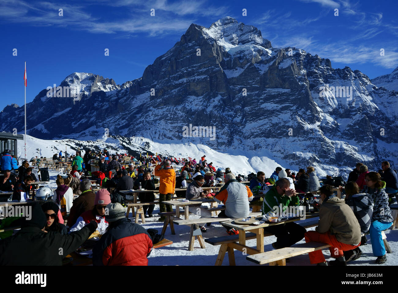 Gli sciatori in all'aperto ristorante a Grindelwald primo skiresort, Mt. Wetterhorn nel retro, alpi Bernesi, Svizzera Foto Stock
