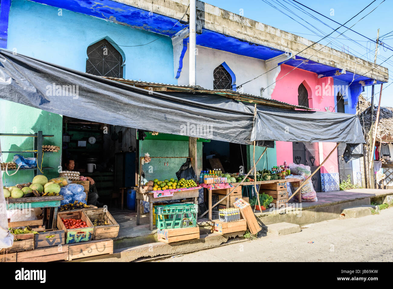 Livingston, Guatemala - agosto 31, 2016: negoziante si siede nella porta del negozio di alimentari nei Caraibi città di Livingston Foto Stock