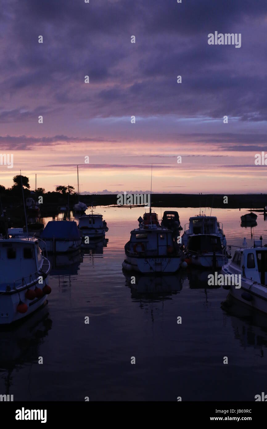 Bellissimo tramonto sul porto di Porlock Weir nel Somerset, nero con sagome di barche in acqua Foto Stock