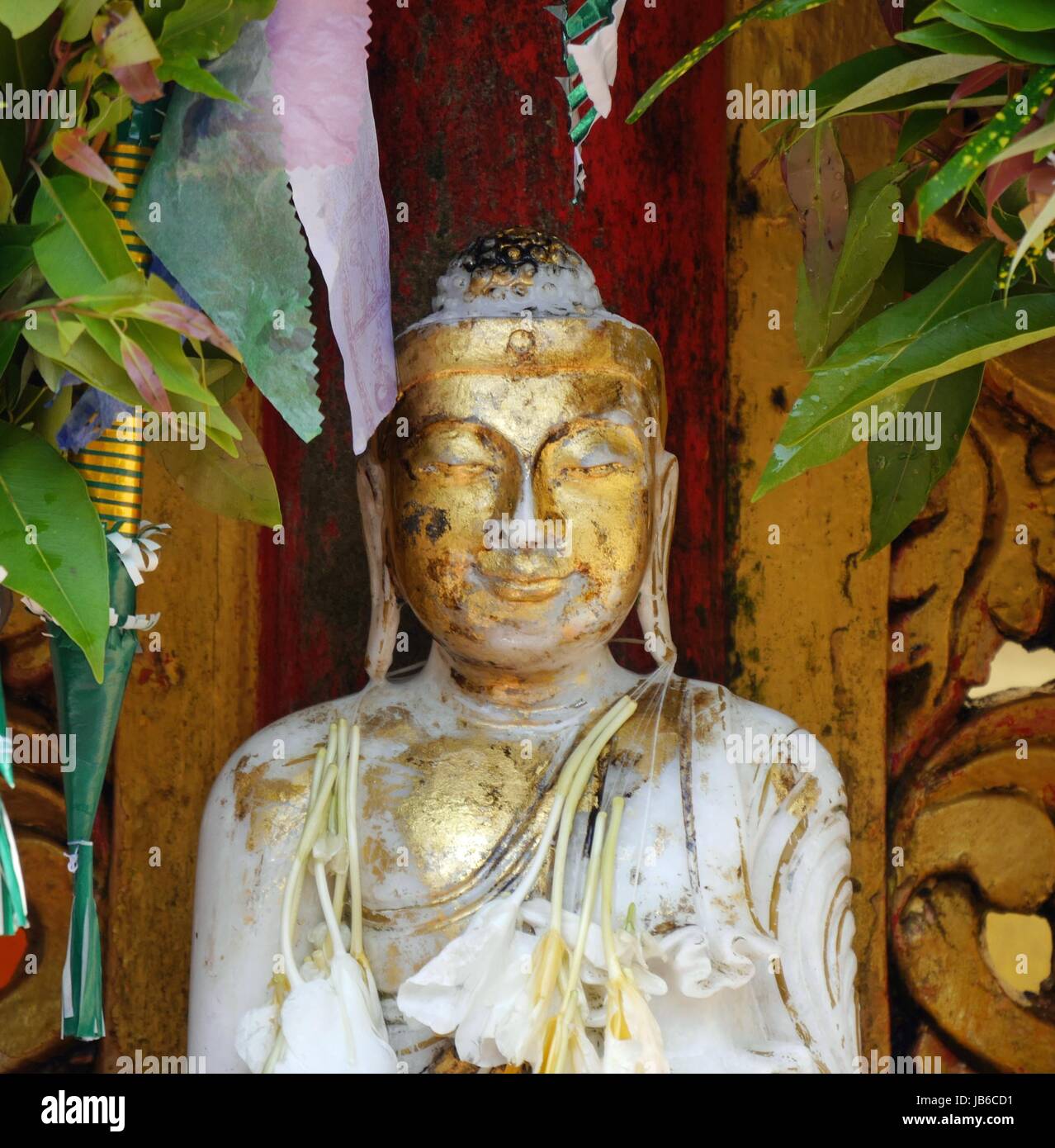 Primo piano di una graziosa figura dorata di Buddha con espressione di serenità Foto Stock