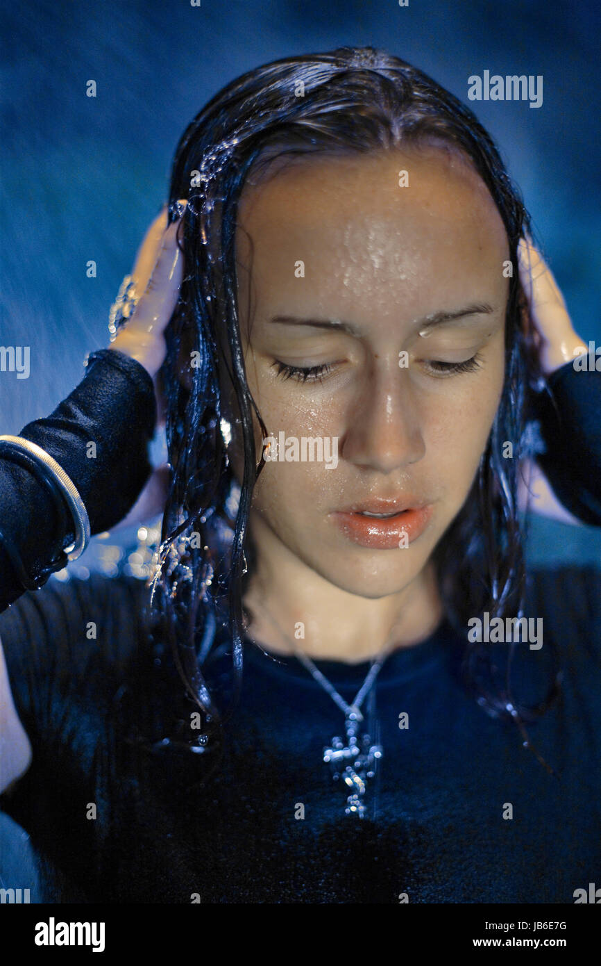 Giovane donna durante la tempesta di notte tenendo la testa. 16, 17, 18, 19, 20, 21, 25 anni, anni Foto Stock