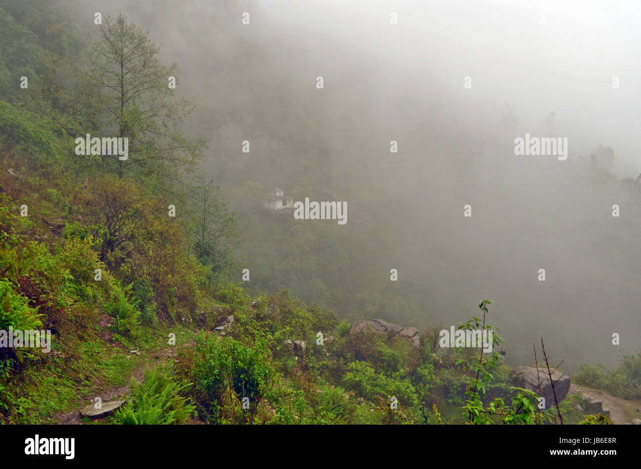 Piccolo tempio sulla collina nella nebbia vicino Landruk, Annapurna Area di conservazione, l'Himalaya Foto Stock