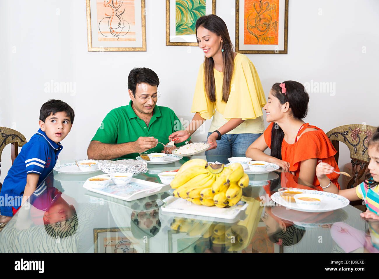 A casa boy cucina sala da pranzo famiglia ragazze Pranzo bimbi genitori che serve Foto Stock