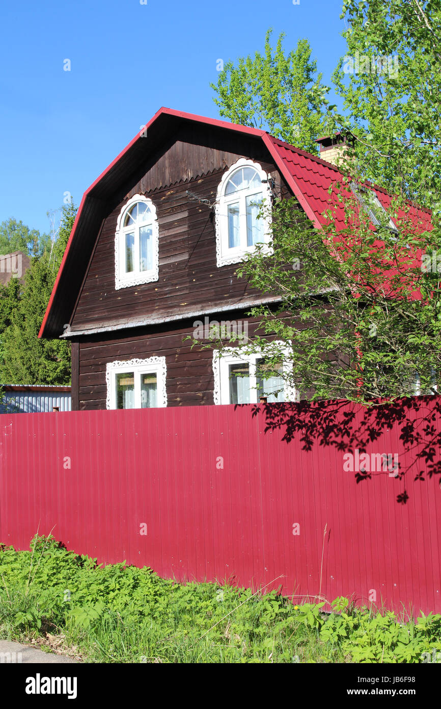 Un moderno in legno una casa di campagna con un recinto luminoso. Europa orientale, Russia Foto Stock