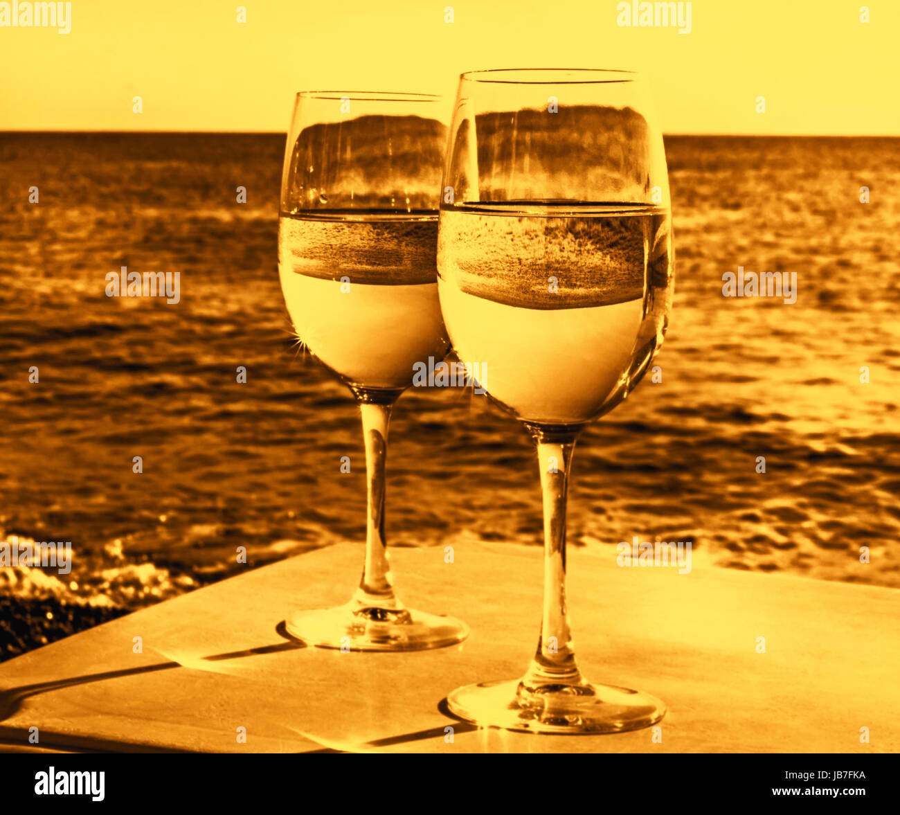 Due bicchieri di vino sulla spiaggia vicino oceano al soleggiato serata equo Foto Stock