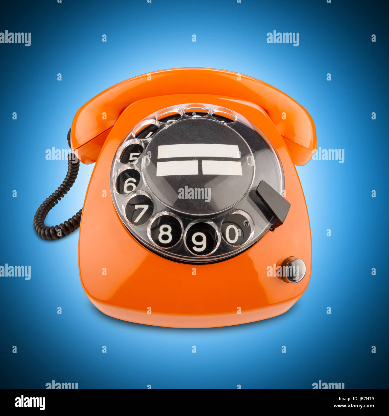 Un vecchio telefono arancione con manopola Foto Stock