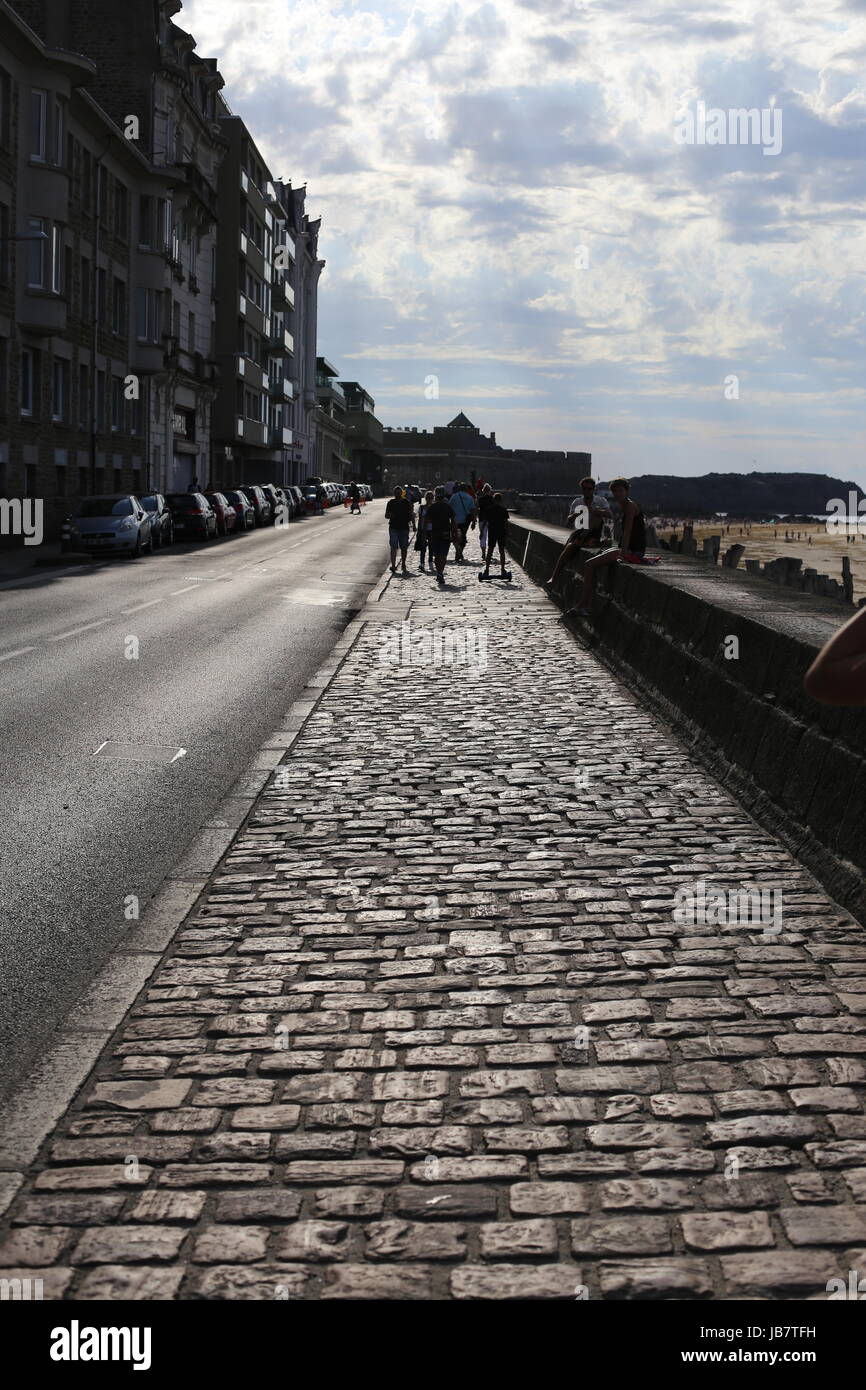 Pavimentazione in ciottoli lungo St Malo fronte spiaggia sulla calda serata di sole Foto Stock