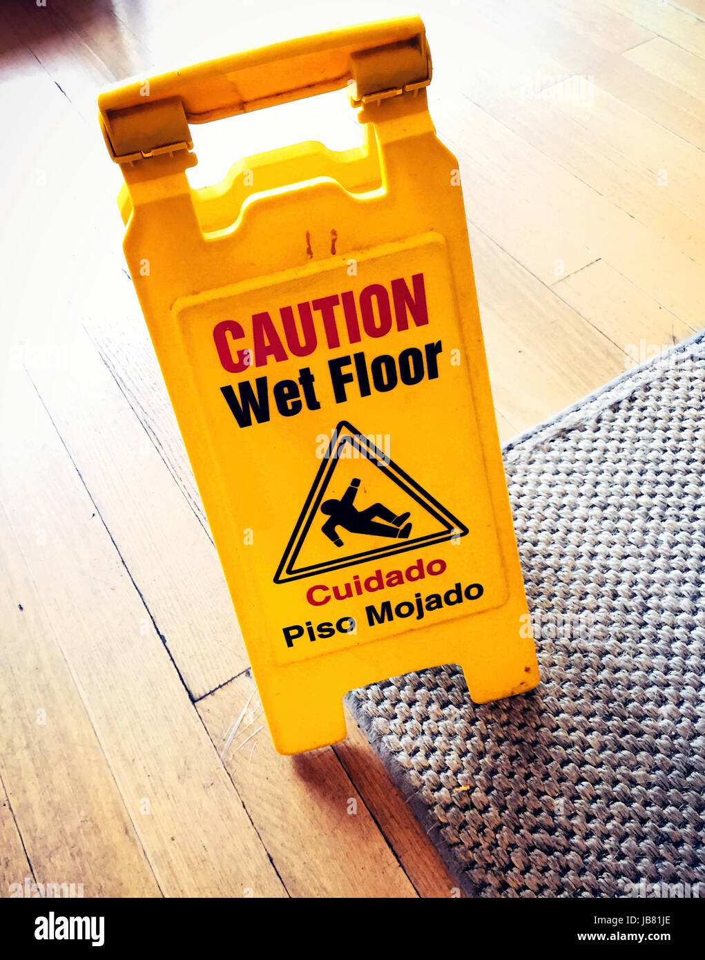 Attenzione pavimento bagnato segno in negozio, NYC, STATI UNITI D'AMERICA Foto Stock