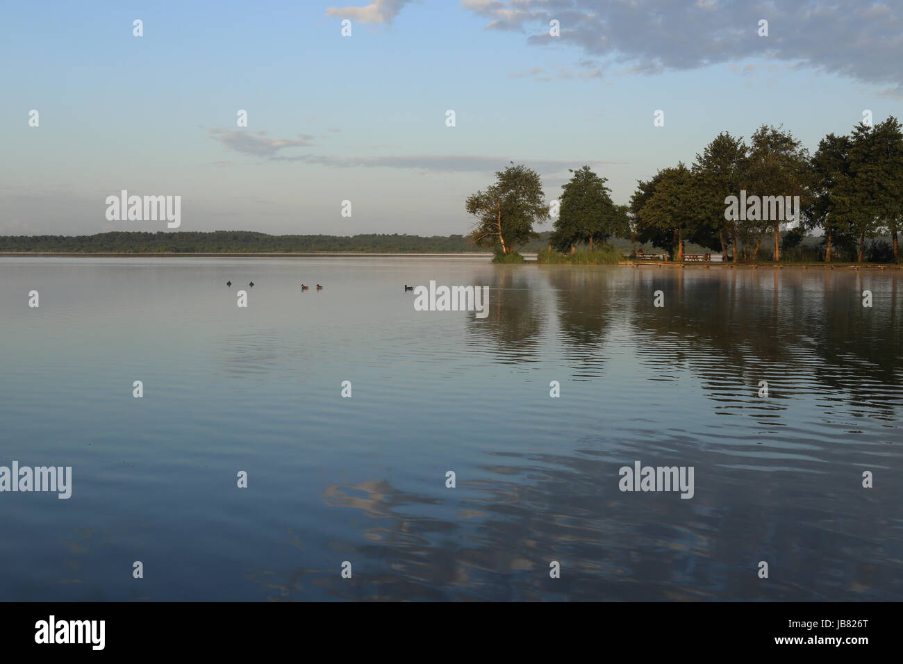 Chiaro e tranquillo lago con riflessi di cielo chiaro Foto Stock