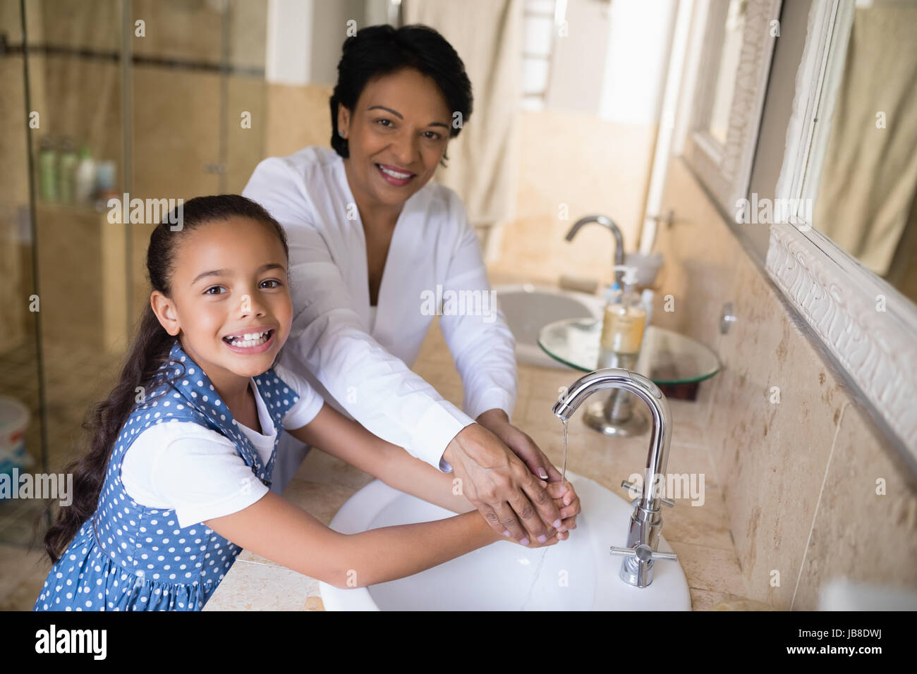Ritratto di Nonna e nipote lavando le mani al lavandino del bagno Foto Stock