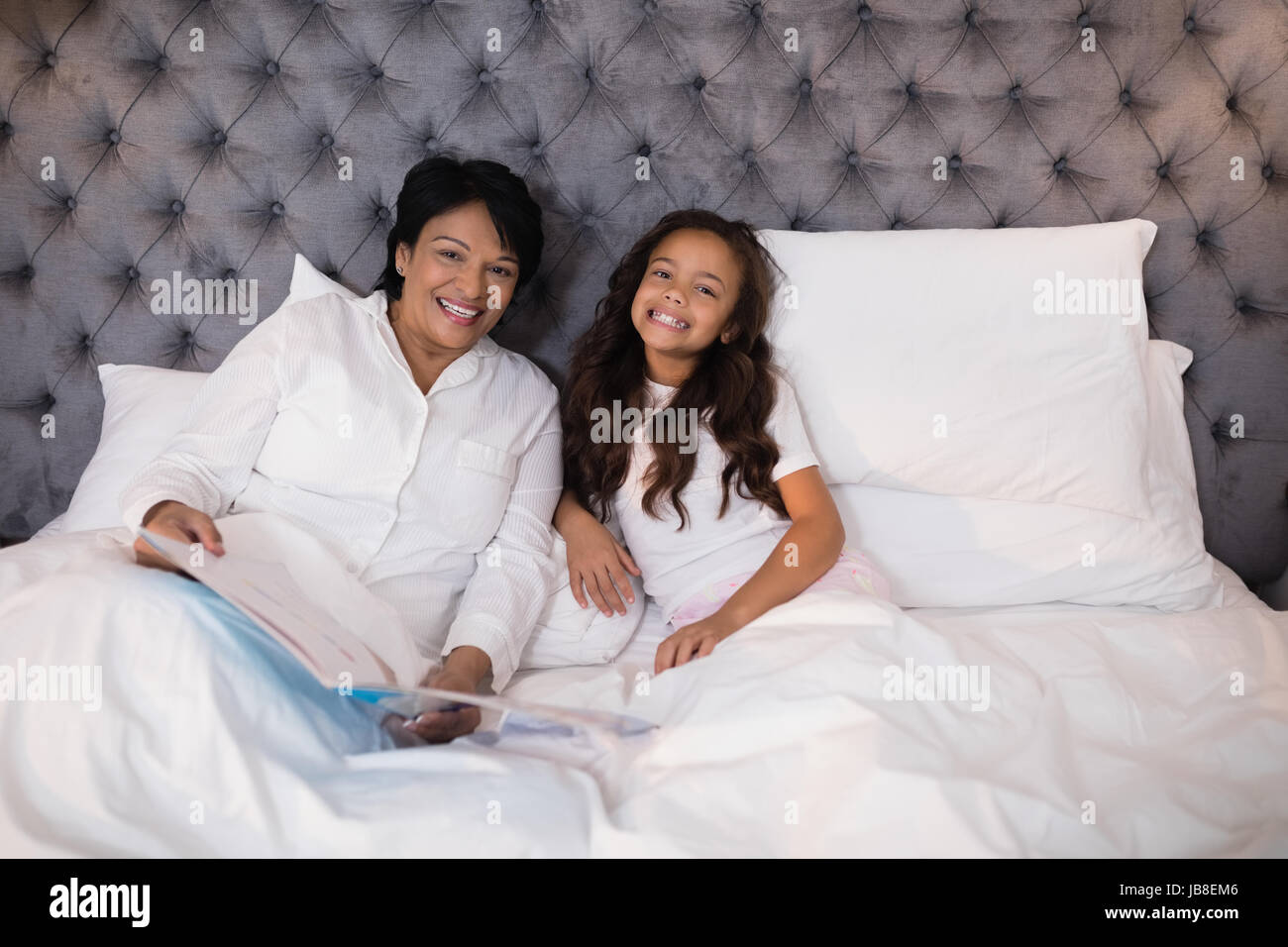 Ritratto di Allegro la nonna e la nipote in appoggio sul letto di casa Foto Stock