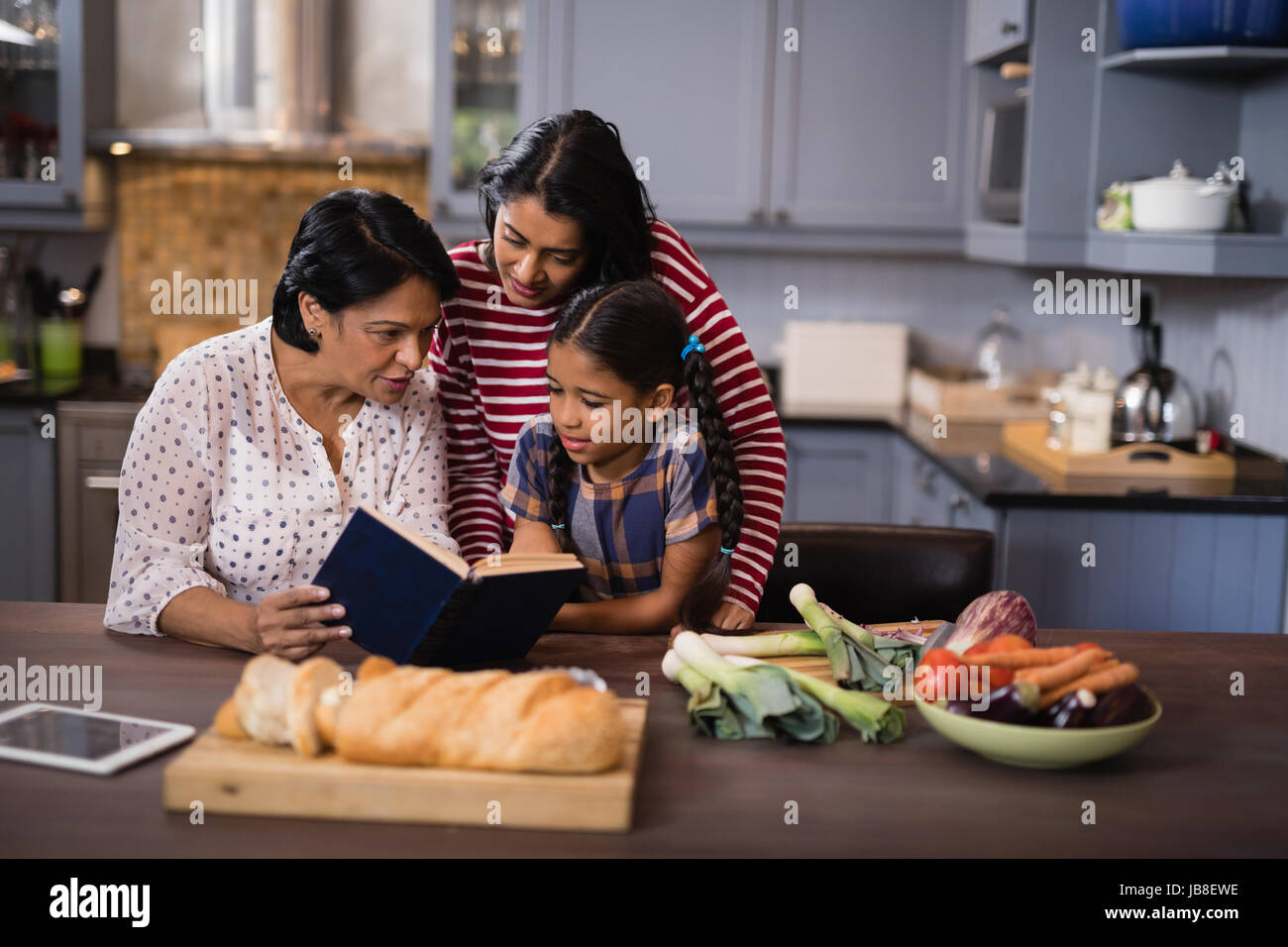 Multi-generazione famiglia seduti insieme in cucina a casa Foto Stock