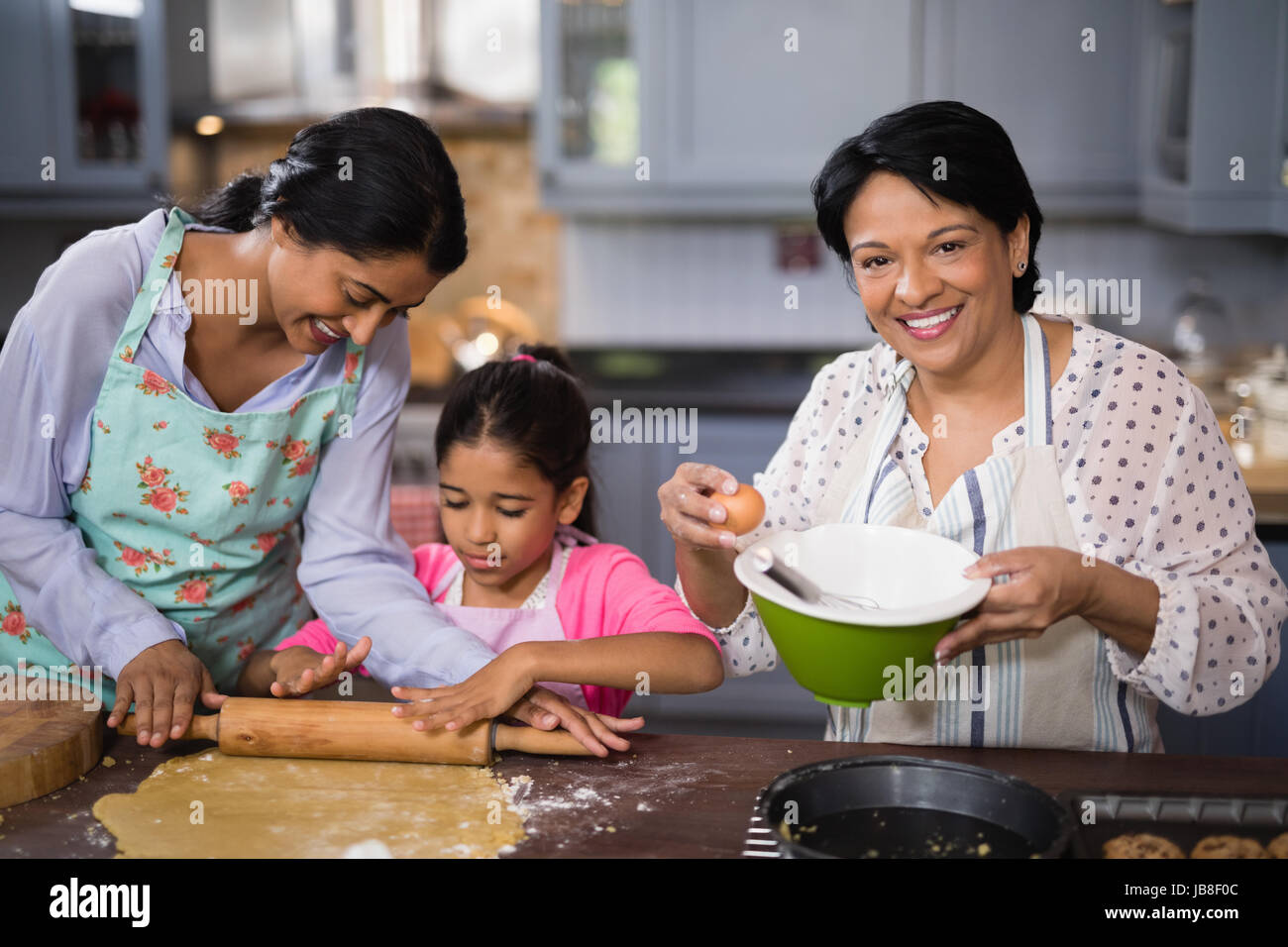Ritratto di donna matura nella preparazione degli alimenti con la famiglia in cucina a casa Foto Stock