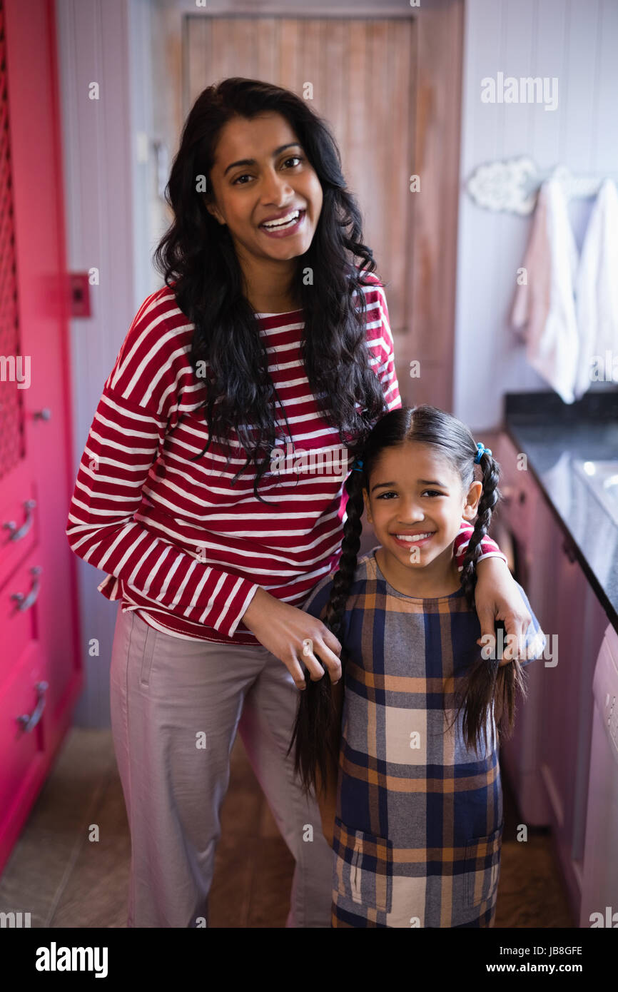 Ritratto di donna felice in piedi con la figlia a casa Foto Stock