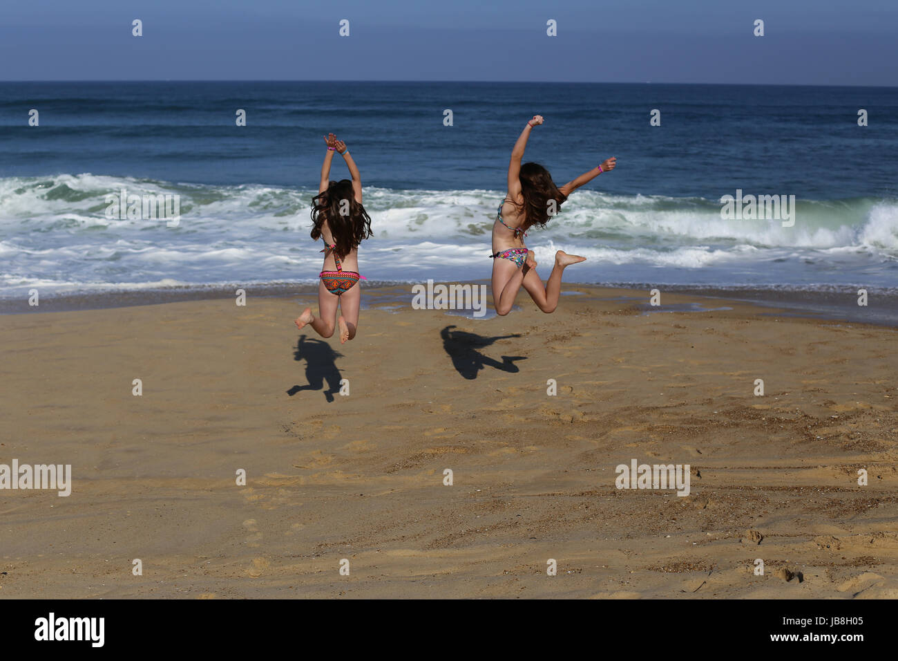 Salti di gioia per l'aria sulla spiaggia vicino al mare sulla spiaggia di messanges, Francia Foto Stock